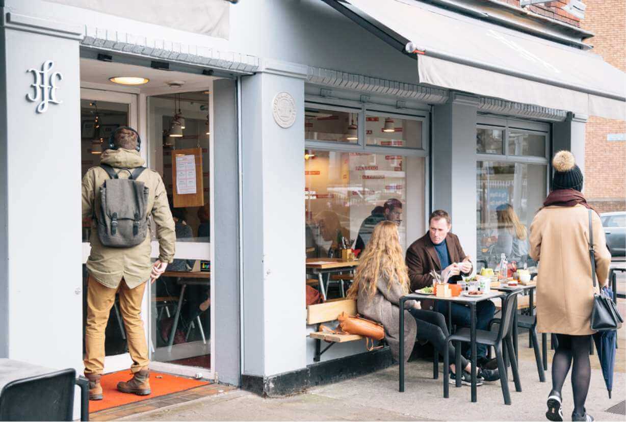 Couple enjoying breakfast outside 3fe local coffee shop a short walk from Lansdowne Place